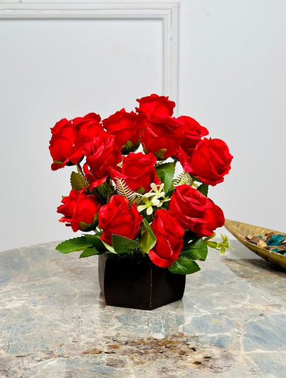 Bouquet of red roses in a black box on a marble surface with a light gray wall background.