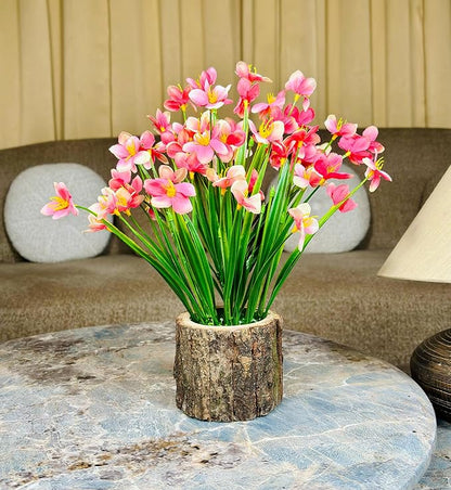 Bouquet of pink flowers in a wooden vase on a marble table with a beige sofa in the background.