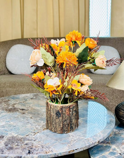 Artificial flower arrangement in a wooden vase on a marble table with a blurred background