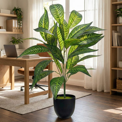 Potted plant in a home office setting with wooden desk and shelves.